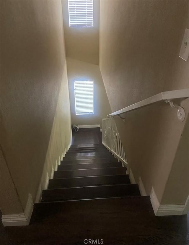 stairway featuring wood finished floors and visible vents