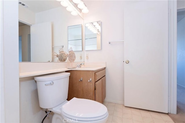 bathroom featuring visible vents, baseboards, toilet, and vanity