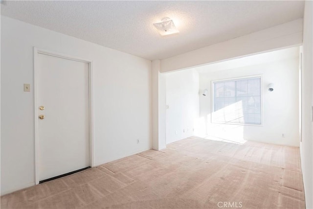 unfurnished room featuring a textured ceiling and carpet