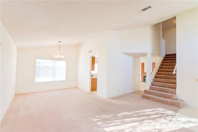 interior space featuring visible vents, carpet, stairway, lofted ceiling, and an inviting chandelier