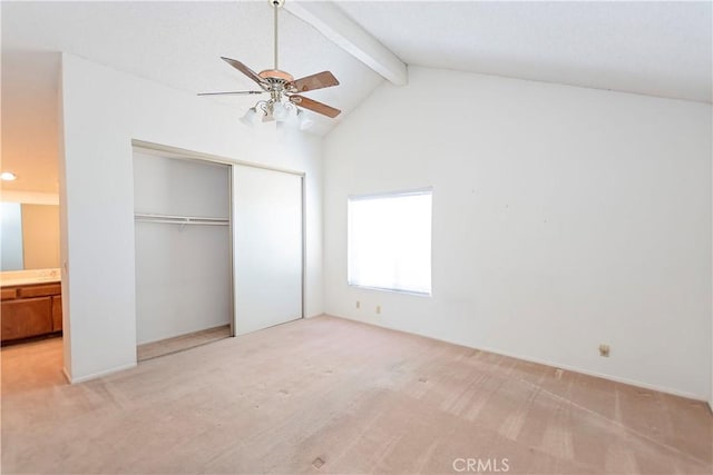 unfurnished bedroom with a closet, a ceiling fan, vaulted ceiling with beams, and carpet flooring