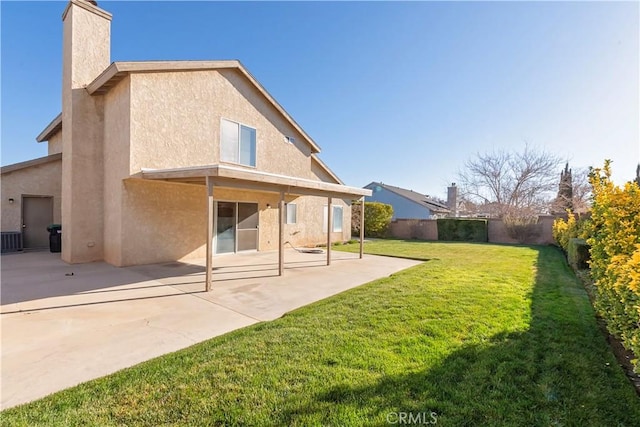 back of property featuring a patio, a fenced backyard, a chimney, stucco siding, and a lawn