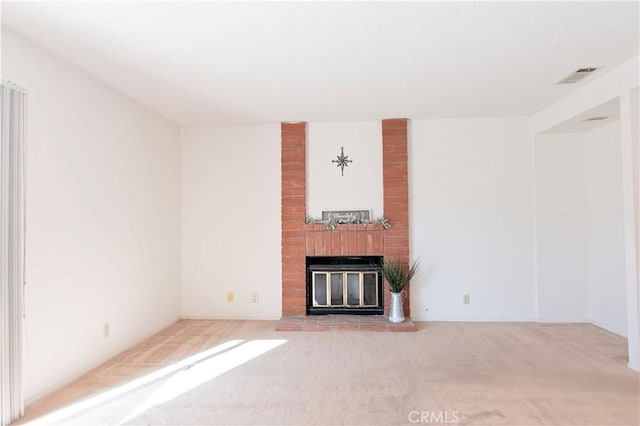 unfurnished living room featuring visible vents, a fireplace, and carpet