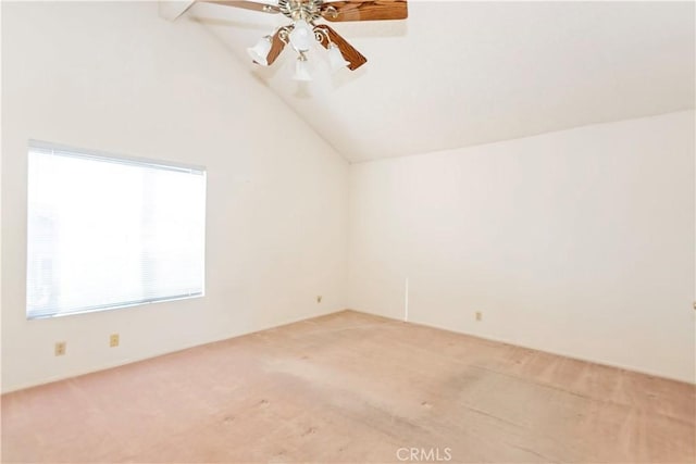 spare room with lofted ceiling, a ceiling fan, and light carpet