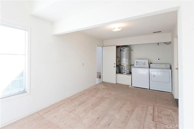 laundry room with gas water heater, a healthy amount of sunlight, laundry area, and washing machine and clothes dryer