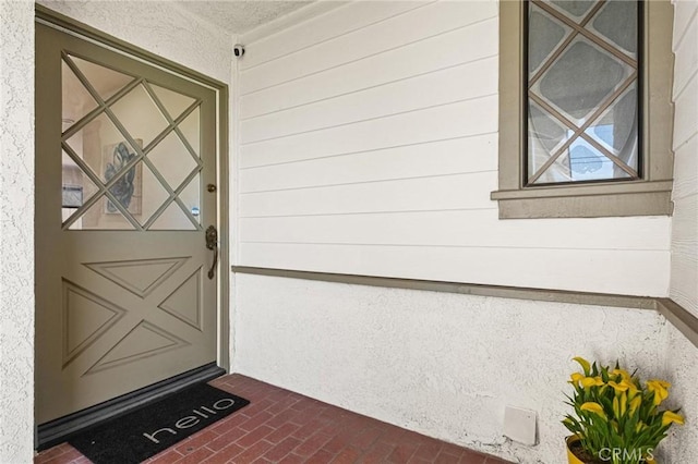 doorway to property featuring stucco siding