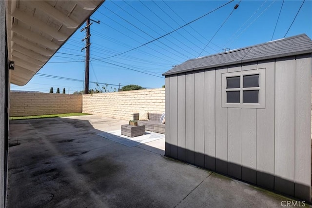 view of patio / terrace with an outbuilding and fence