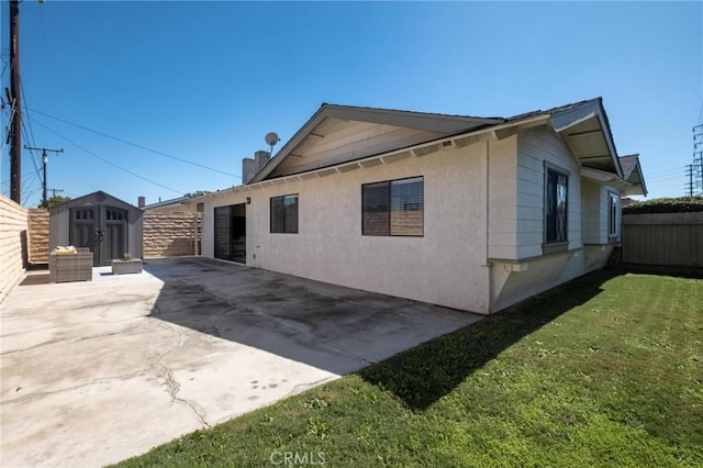 view of property exterior with concrete driveway, a fenced backyard, an outbuilding, a storage unit, and a patio