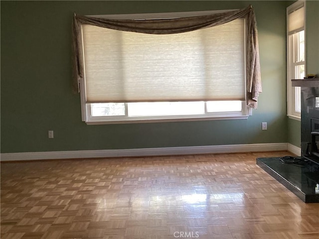 interior space featuring a wealth of natural light, a wood stove, and baseboards
