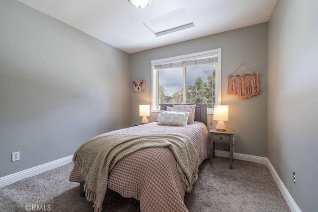 carpeted bedroom featuring attic access and baseboards