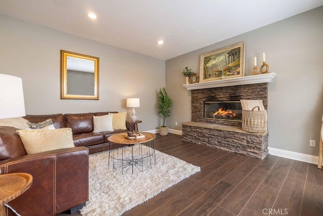 living room with a stone fireplace, recessed lighting, dark wood-style floors, and baseboards