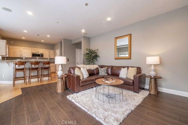 living area with recessed lighting, baseboards, and dark wood-style flooring