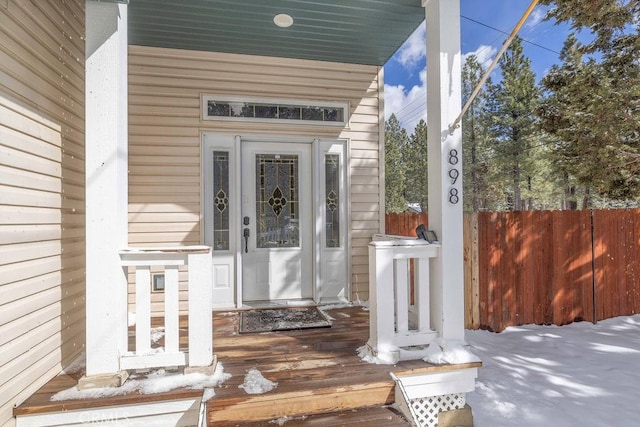 doorway to property with fence and covered porch