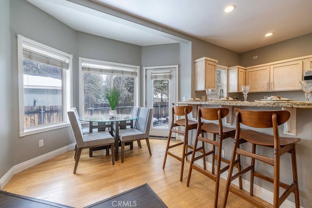 kitchen featuring light brown cabinets, a healthy amount of sunlight, baseboards, and light wood finished floors