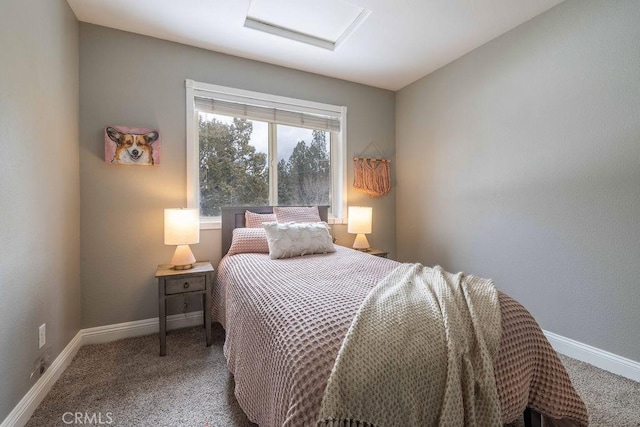 carpeted bedroom featuring attic access and baseboards