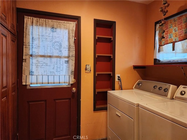 laundry room with laundry area, separate washer and dryer, and a healthy amount of sunlight