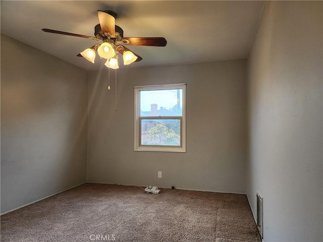 carpeted spare room with visible vents and ceiling fan