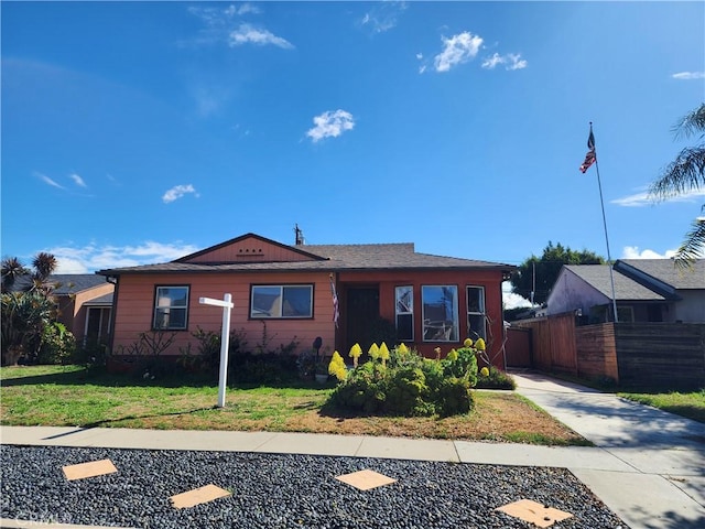 view of front facade featuring a front yard and fence