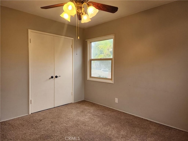 unfurnished bedroom with a closet, a ceiling fan, and carpet flooring