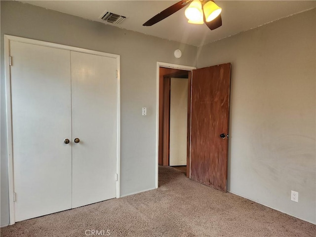 unfurnished bedroom featuring a ceiling fan, carpet, visible vents, and a closet