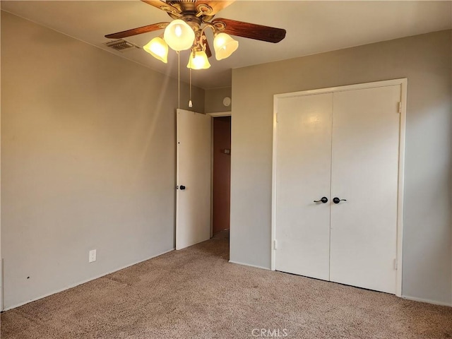 unfurnished bedroom with carpet, visible vents, a closet, and ceiling fan