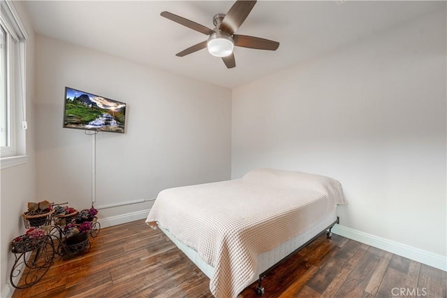 bedroom featuring baseboards, wood finished floors, and a ceiling fan