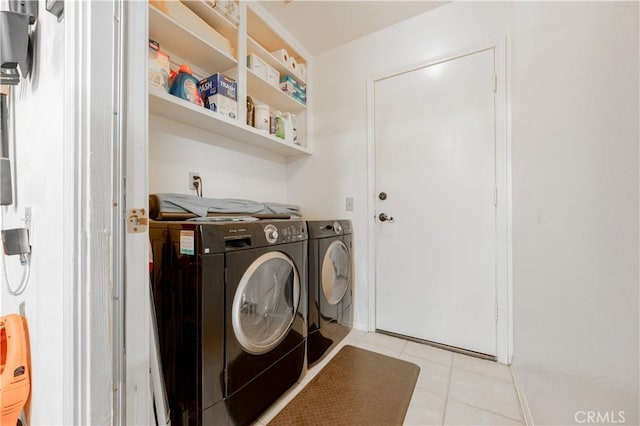 laundry room featuring light tile patterned floors, separate washer and dryer, and laundry area