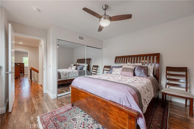 bedroom featuring visible vents, ceiling fan, baseboards, wood finished floors, and a closet