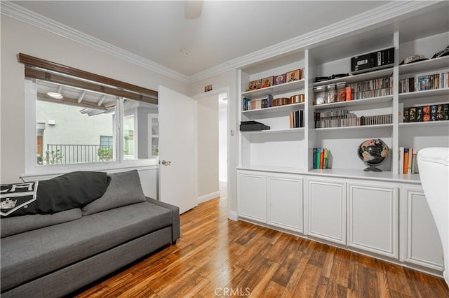 living area with wood finished floors and ornamental molding