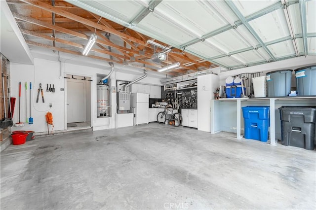 garage featuring gas water heater, a garage door opener, and freestanding refrigerator