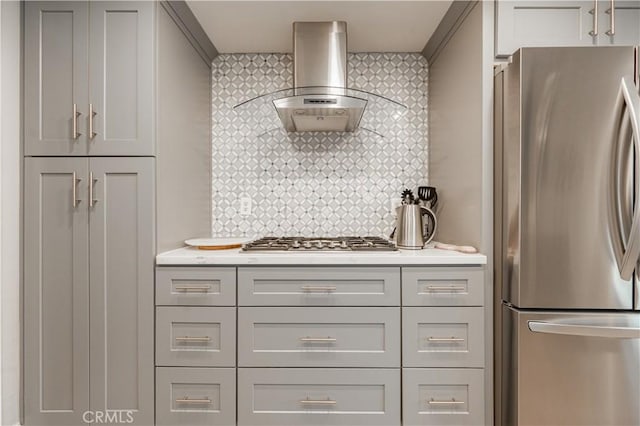 kitchen with stainless steel appliances, light countertops, gray cabinets, and wall chimney range hood