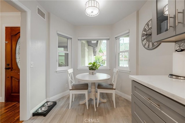 dining space featuring visible vents, light wood-type flooring, and baseboards