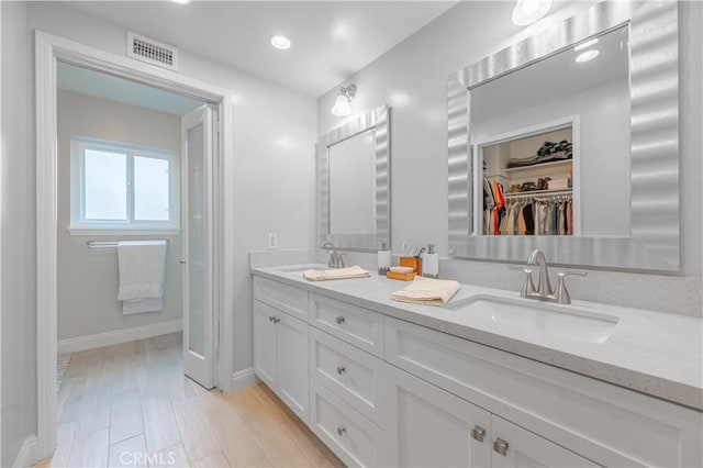 full bathroom featuring double vanity, baseboards, visible vents, and a sink