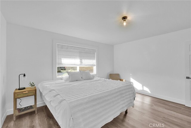 bedroom featuring wood finished floors and baseboards