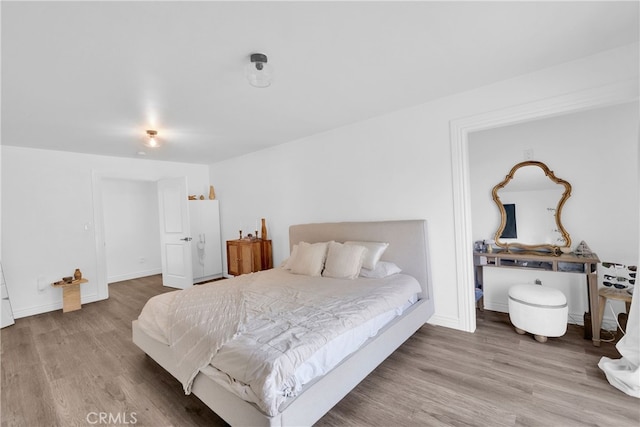 bedroom with baseboards and wood finished floors