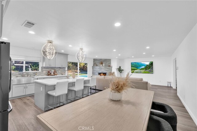 dining area featuring recessed lighting, visible vents, light wood-style floors, and a fireplace