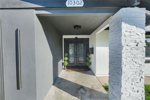 property entrance with french doors and stucco siding