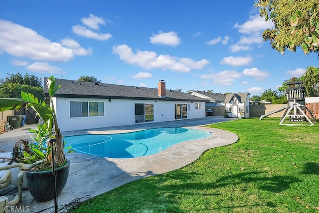 view of swimming pool featuring a patio, a shed, a playground, a yard, and an outdoor structure