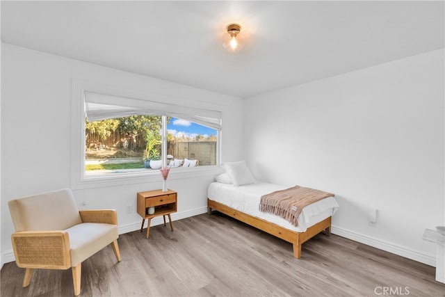 bedroom with light wood-style floors and baseboards