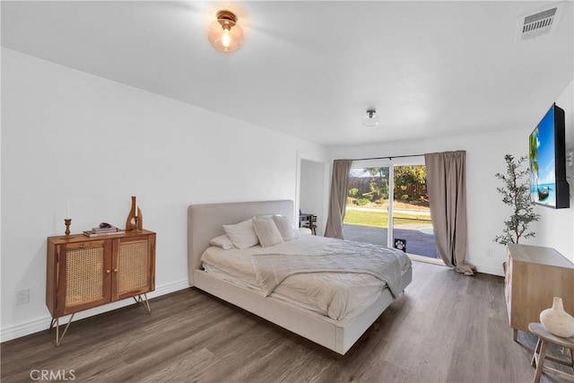 bedroom featuring access to outside, wood finished floors, visible vents, and baseboards