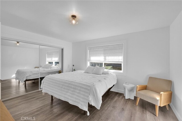 bedroom featuring wood finished floors, a closet, and baseboards