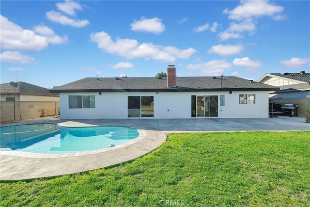 back of house featuring a fenced backyard, a patio, a chimney, and a yard