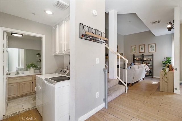 14039 Astoria St Unit 120, Sylmar, CA 91342 - laundry area featuring separate washer and dryer, light wood-type flooring, and cabinet space
