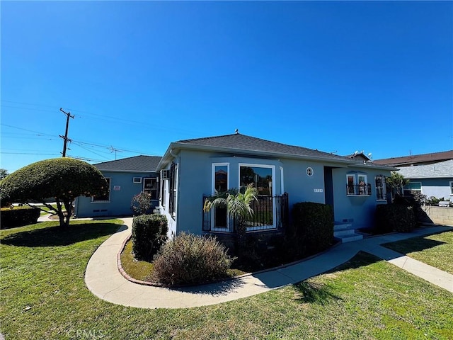 view of front of home with a front lawn and stucco siding