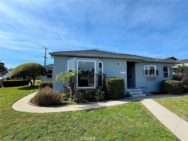 view of front of house featuring a front lawn and stucco siding