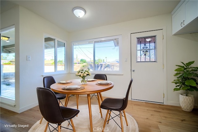 dining area featuring baseboards and light wood finished floors