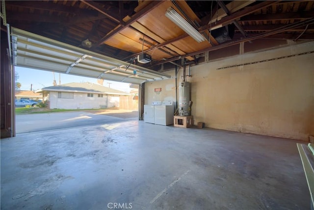 garage featuring a garage door opener, water heater, and washer and clothes dryer