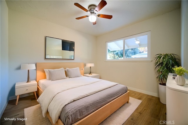 bedroom featuring wood finished floors, baseboards, and ceiling fan