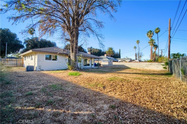 exterior space with stucco siding, central AC, and fence