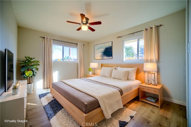 bedroom featuring ceiling fan, baseboards, and light wood-style floors